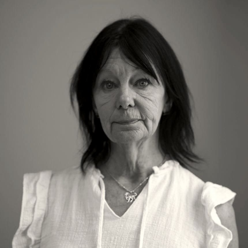 Black-and-white photo of former YDC staffer Karen Lemoine. She is an older woman with dark hair, wearing a white top, and a necklace with a horse pendant.